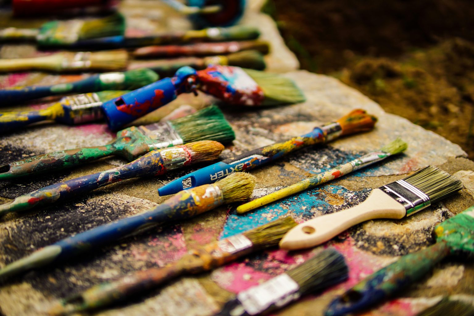 Kunstenaars met kwasten tijdens een schilderworkshop, klaar om creatief aan de slag te gaan met hun schilderwerk